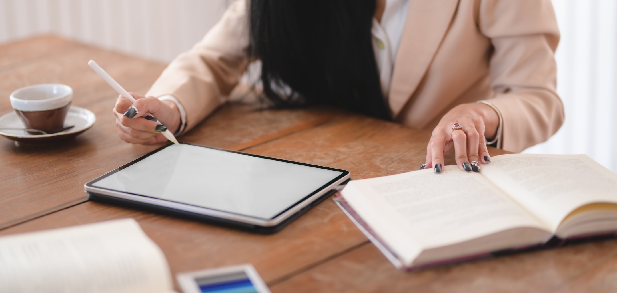 Photo of Woman Using Tablet While Holding Book